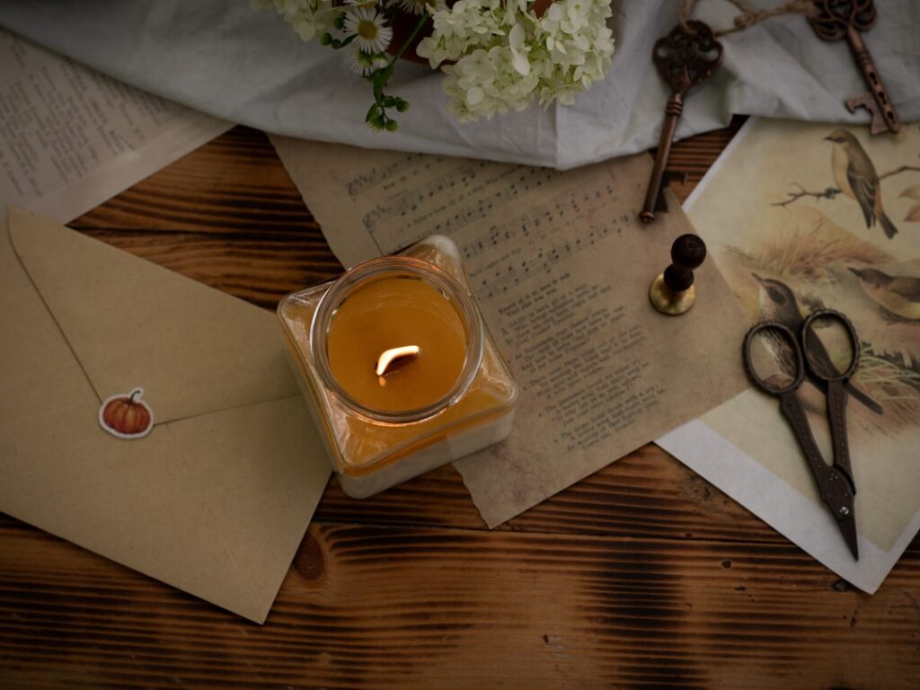 a candle sits on a table next to a pair of scissors ttwgojcpkns a candle sits on a table next to a pair of scissors ttwgojcpkns
